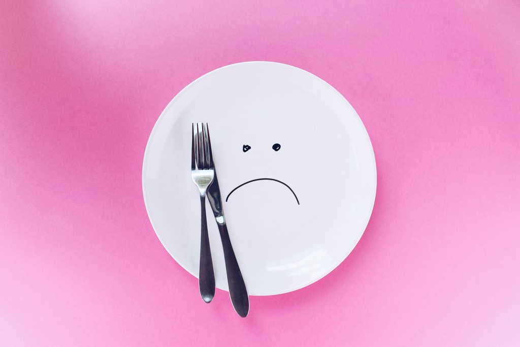 Plate with sad face on it, symbolizing an eating disorder caused by trauma