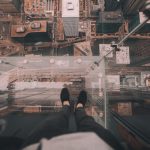 person standing on the edge of a tall building