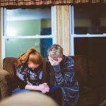 two depressed teens sitting on a sofa