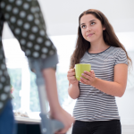 teenager comforting disabled parent with cup of coffee